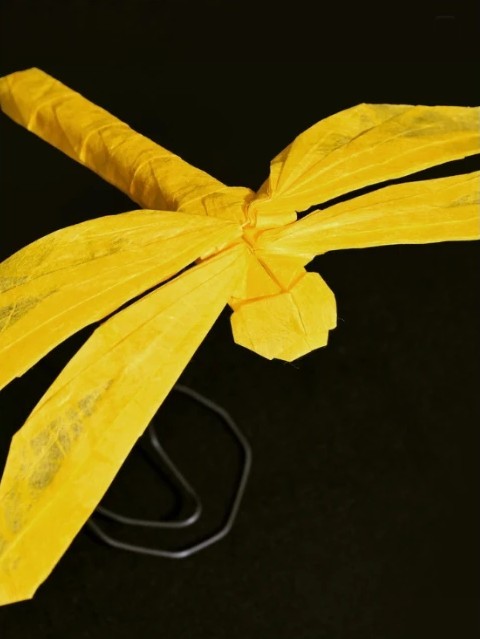Origami dragonfly folded from yellow paper