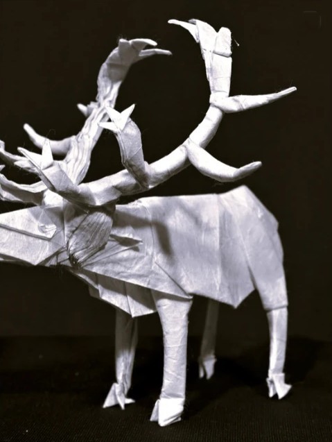 Origami moose with huge antlers folded from white paper