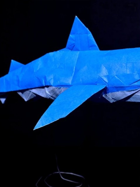 Origami shark folded from bright blue paper